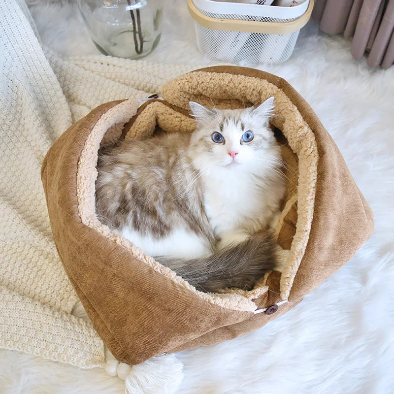 Cat sitting in a brown pet bed on a soft surface