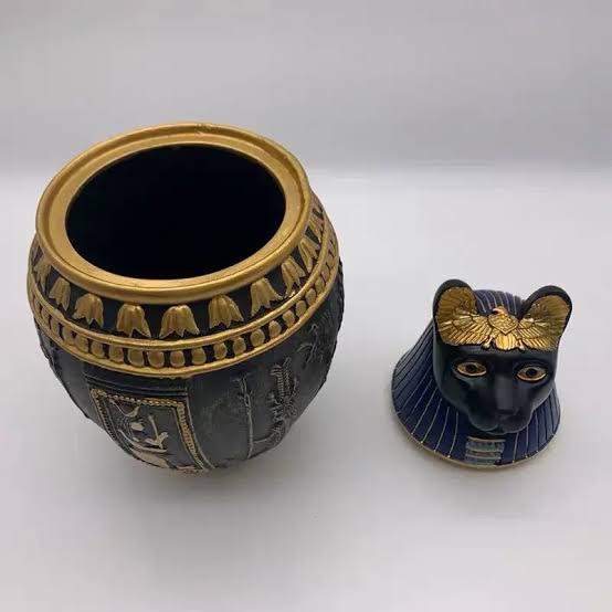 Decorative pet cremation jar portraying Ancient Egyptian goddess Bastet, displayed open on white background.