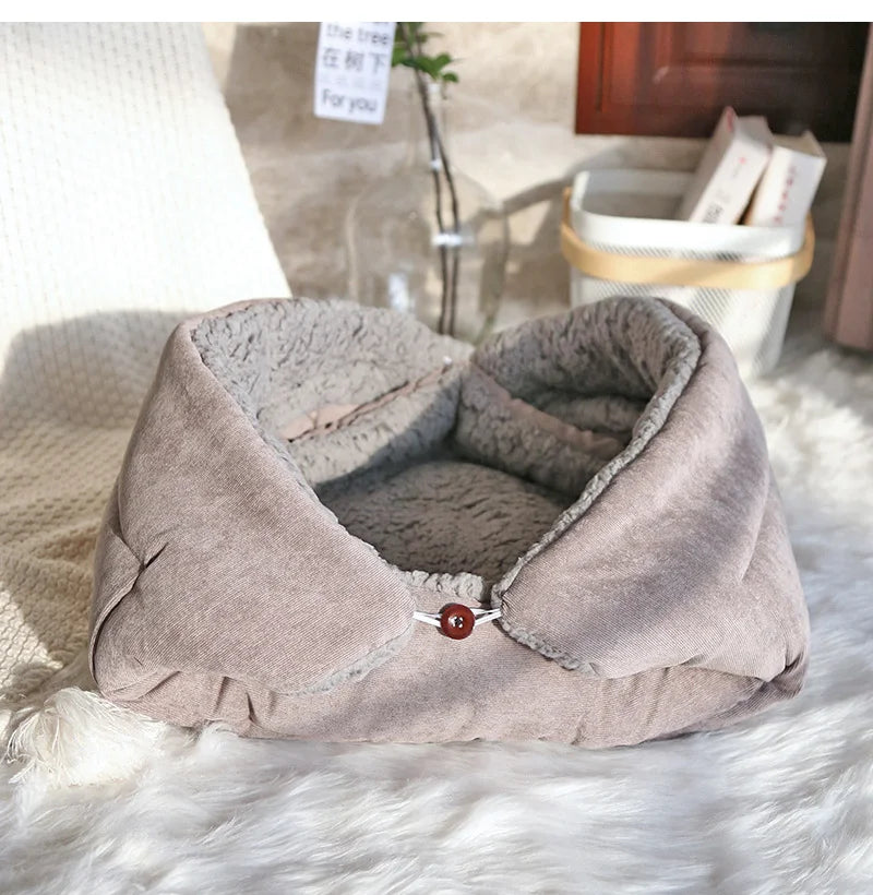Gray pet bed on a white surface with a blurred background
