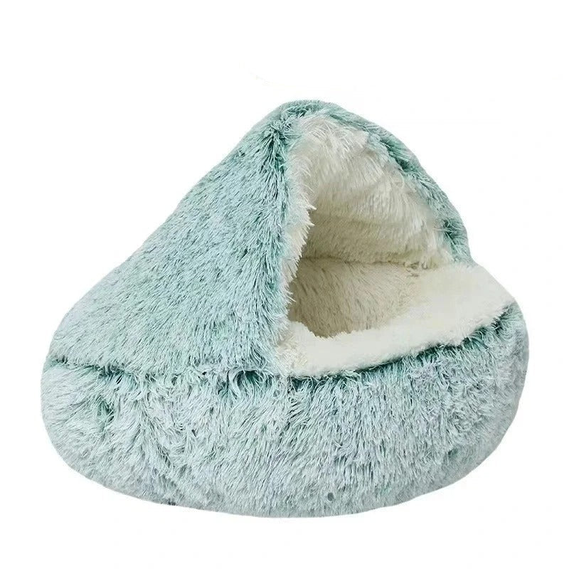 Green plush calming cat bed with white fluffy interior displayed on a white background.