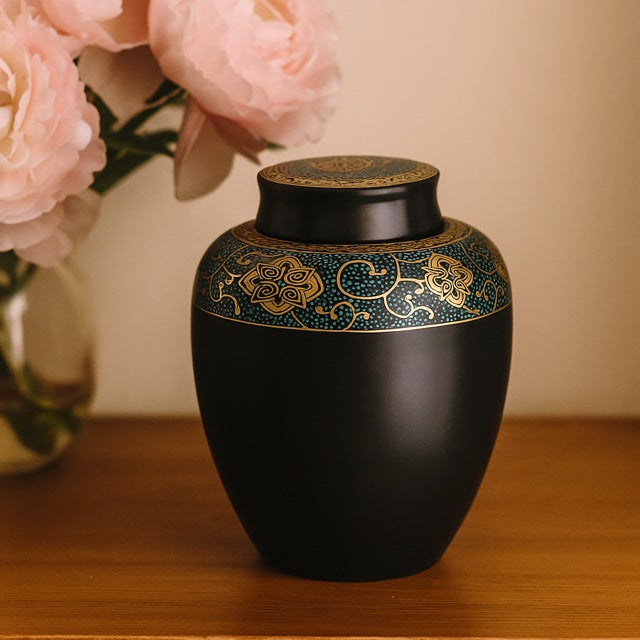 Elegant urn for pet ashes displayed on a wooden bench with peonies in background - a quiet way to honour a beloved pet.