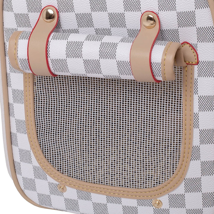 Close-up of a chequered leather pet carrier with mesh pocket and leather straps.