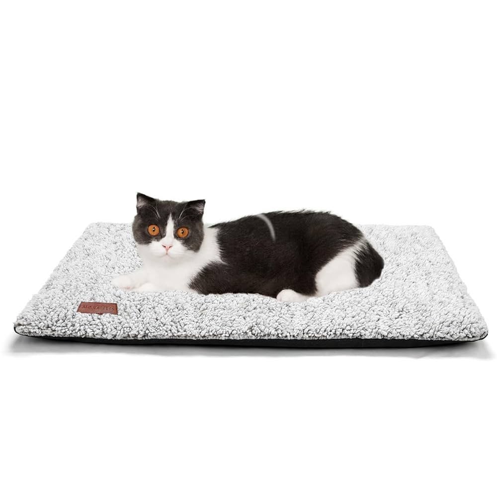 Grey self-warming cat bed with a black and white cat laying on top of it, displayed on a white background.