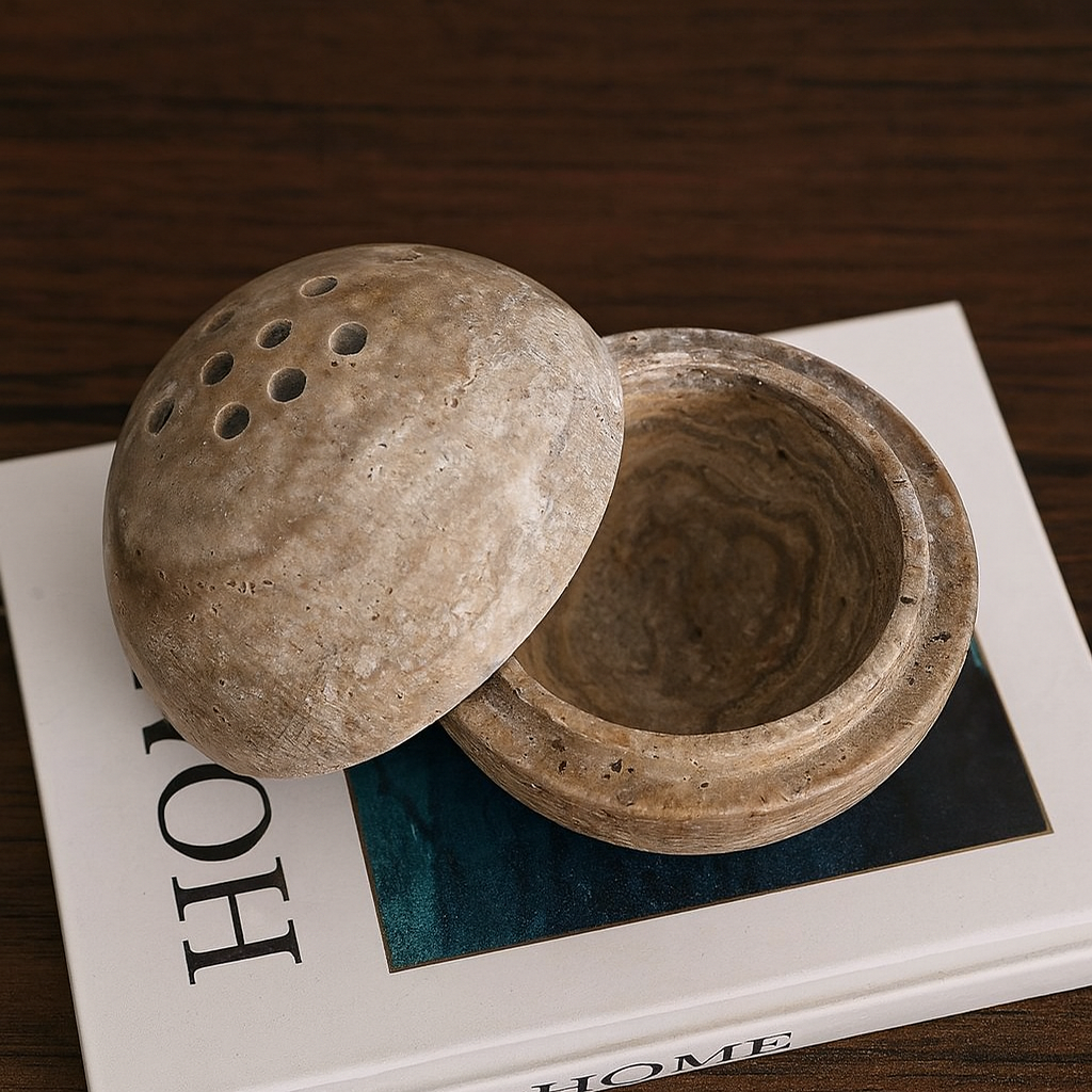 Beige stone incense burner on a Home magazine on a wooden surface.