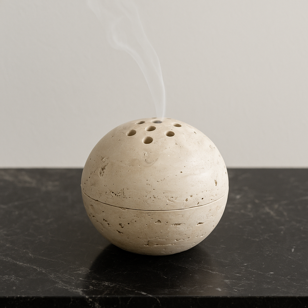 Stone incense burner with smoke on a dark marble surface.
