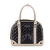 Black quilted handbag with beige handle and trim on a white background