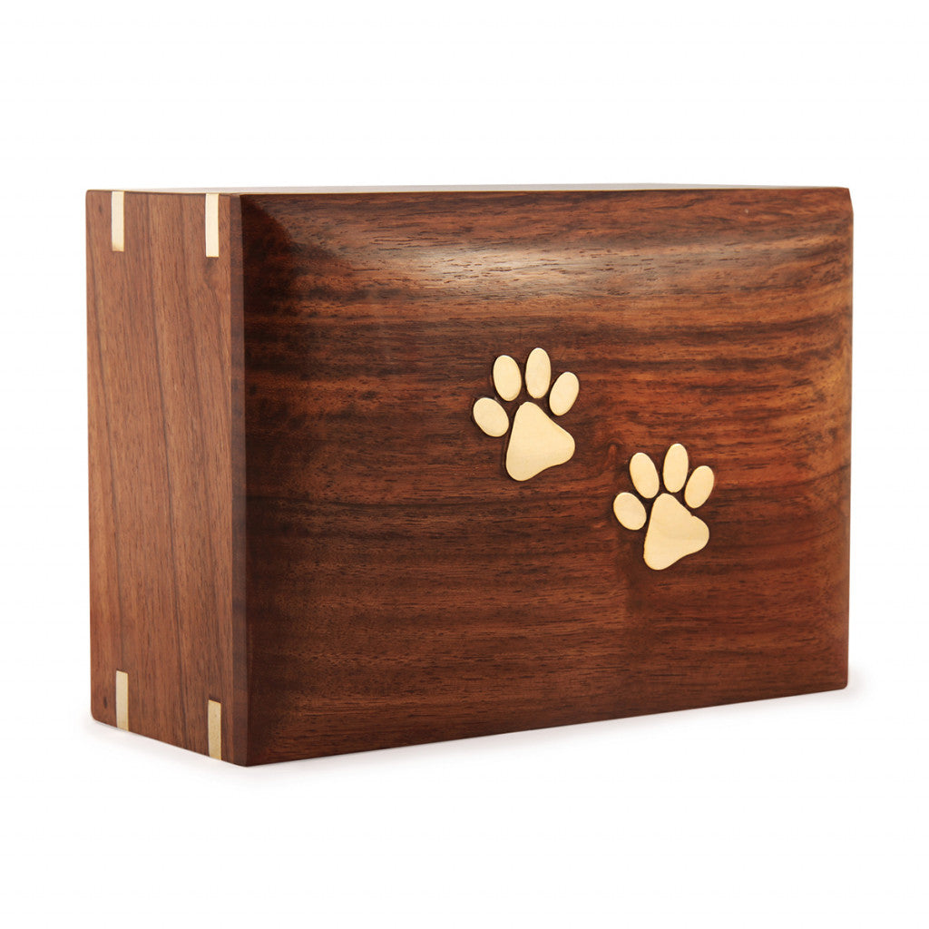 A handmade cremation box for pet ashes made from wood with engraved paw prints displayed on a white background.