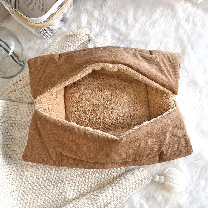 Brown pet bed with fleece lining on a soft white surface