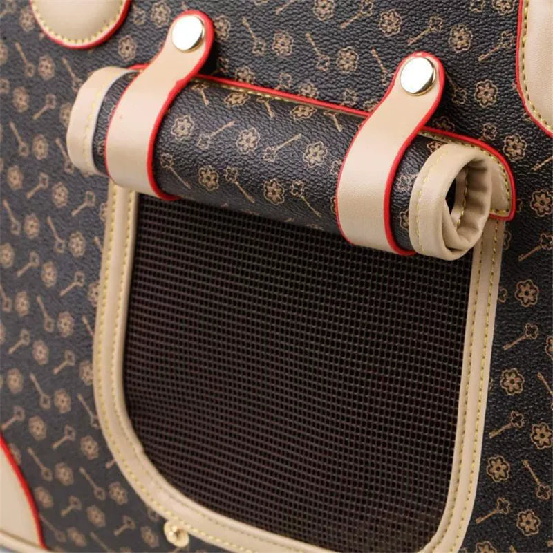 Close-up of a leather pet carrier with a pattern and mesh door.