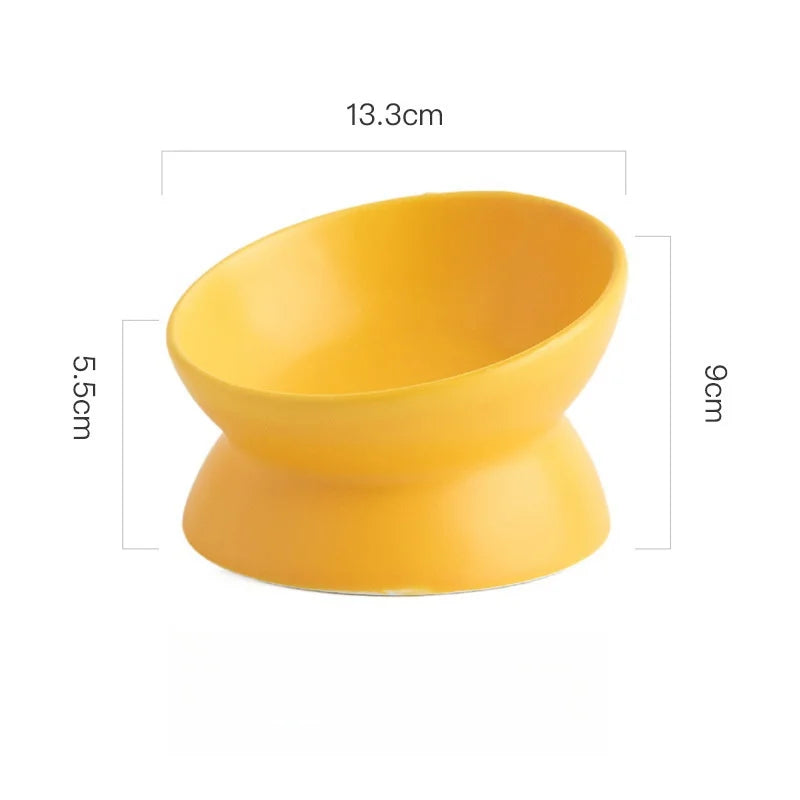 Yellow ceramic elevated cat bowl with measurements displayed on a white background.