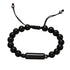 Black onyx bead cremation urn bracelet with adjustable black cord and a cylindrical metal urn pendant in the centre, displayed on a white background
