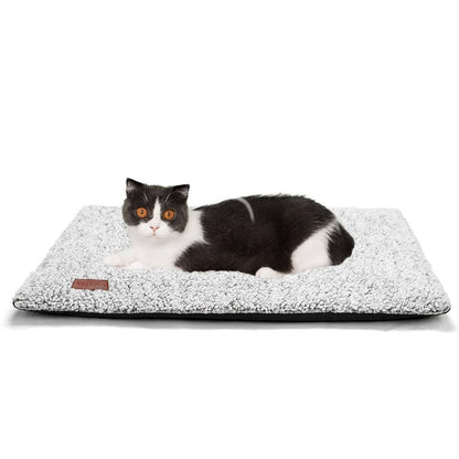 Grey self-warming cat bed with a black and white cat laying on top of it, displayed on a white background.