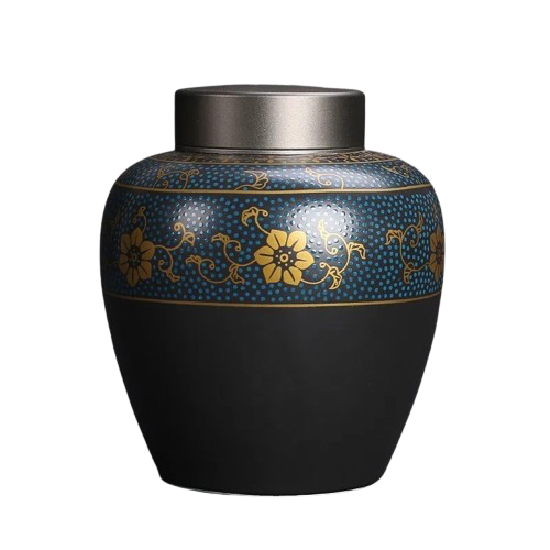 Ceramic black pet cremation urn with a gold and blue ornament displayed on a white background.
