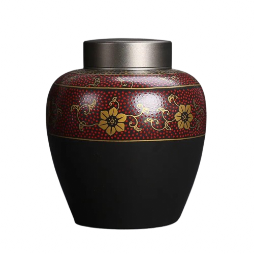 Black matte urn with gold and red ornament displayed on a white background - a meaningful an discreet way to honour your beloved pet.