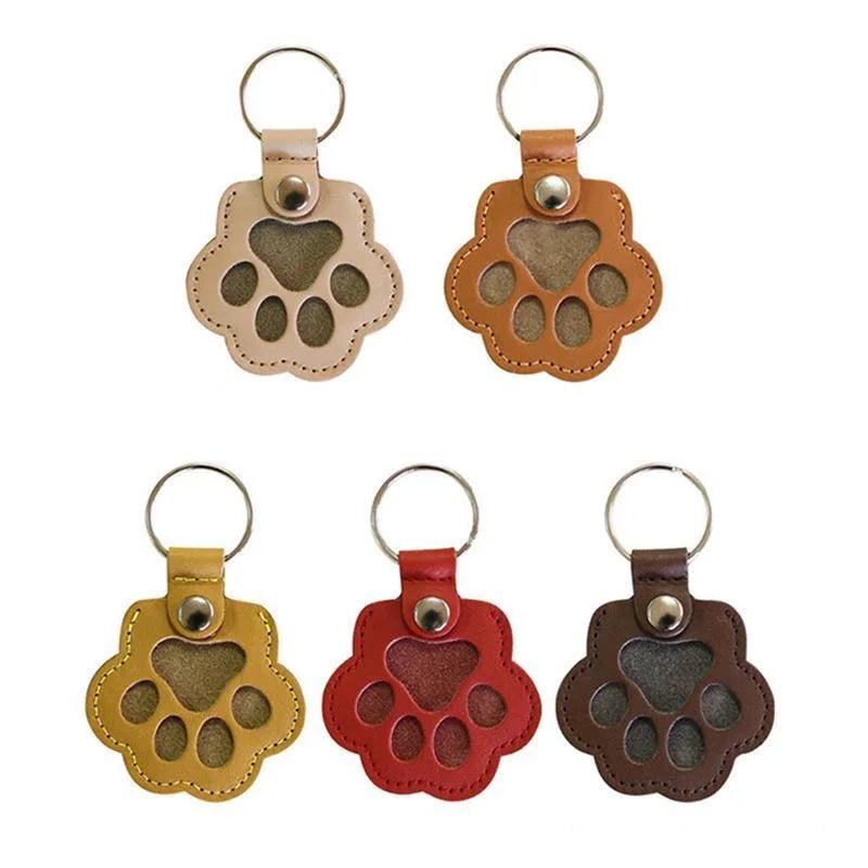 Set of five leather paw shape key rings in different colours displayed on a white background.