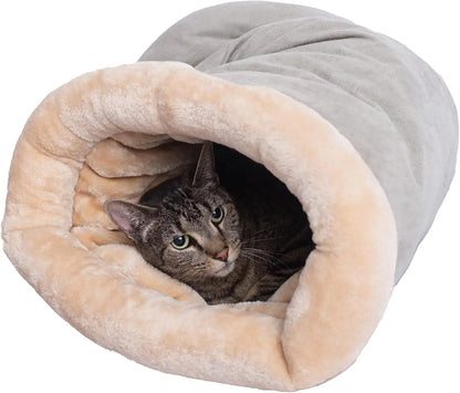 Cat peeking out from a plush, beige and grey pet sleeping bag on a white background.